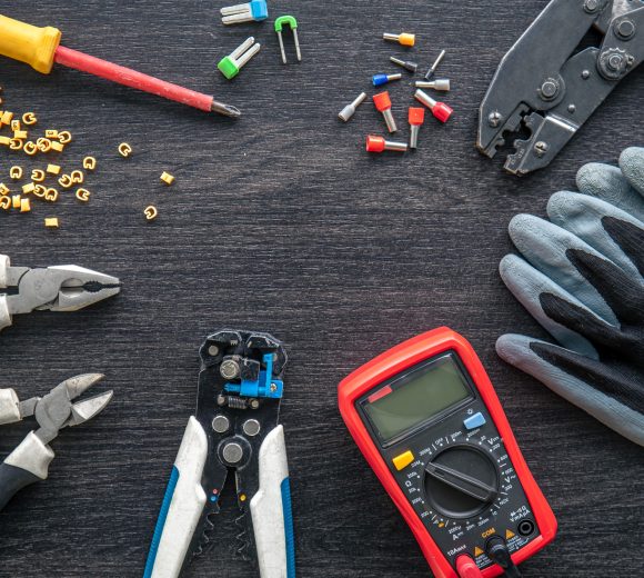 Flat lay composition with electrical tools on wooden background.